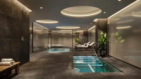 Elegant indoor recovery space at Biohack Miami with spa pools, ambient lighting, lounge seating, and lush plants for a premium wellness experience